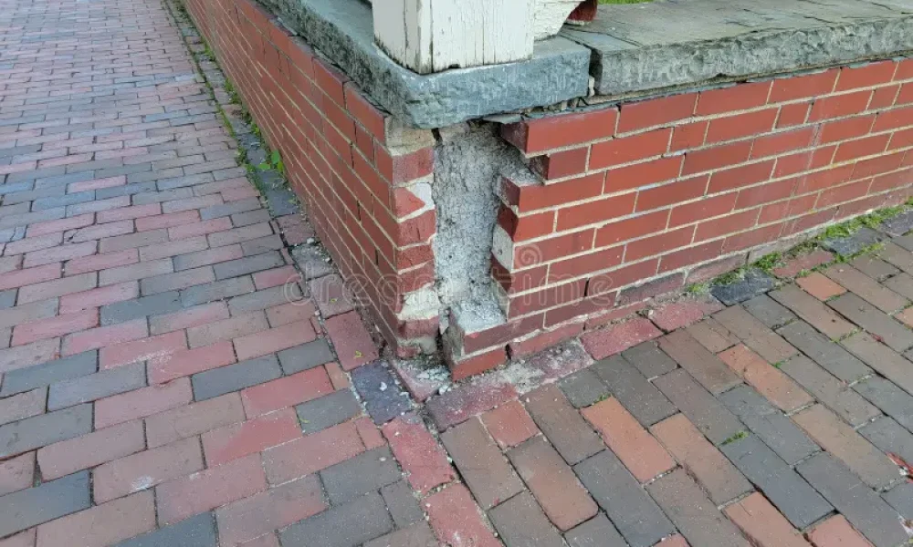 damaged-corner-brick-wall-masonry-broken-sidewalk-249144450